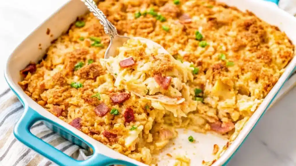 Creamy Neiman Marcus chicken casserole topped with crispy bacon and golden breadcrumbs in a blue baking dish.