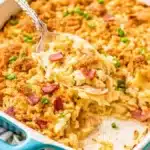 Creamy Neiman Marcus chicken casserole topped with crispy bacon and golden breadcrumbs in a blue baking dish.